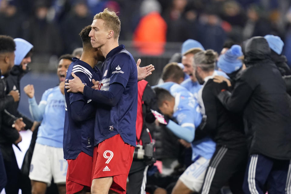 New England Revolution forward Adam Buksa (9) is embraced by midfielder Brandon Bye after the team's 3-2 loss to New York City FC in an MLS playoff soccer match Tuesday, Nov. 30, 2021, in Foxborough, Mass. (AP Photo/Charles Krupa)