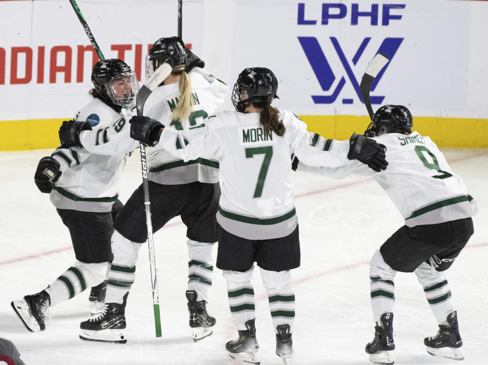 Boston's Taylor Wenczkowski, left, celebrates her goal against Montreal with Gigi Marvin (19), Sidney Morin (7) and Sophie Shirley (9) during the third overtime of a PWHL playoff hockey game in Laval, Quebec, Saturday, May 11, 2024. (Christinne Muschi/The Canadian Press via AP)