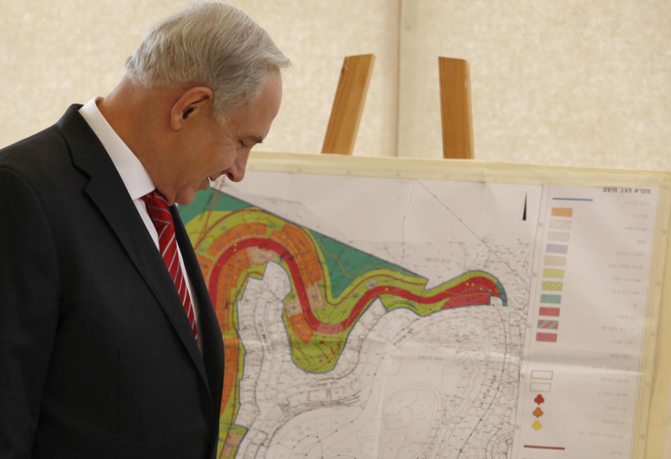 Israeli Prime Minister Benjamin Netanyahu looks at a map of the area where Israel plans to build some 800 new housing units during his visit to the east Jerusalem Jewish neighborhood of Gilo, Tuesday, Oct. 23, 2012. Netanyahu vowed on Tuesday to continue building in the Jerusalem district days after European Union criticism because it is claimed by Palestinians. (AP Photo/Gali Tibbon, Pool)