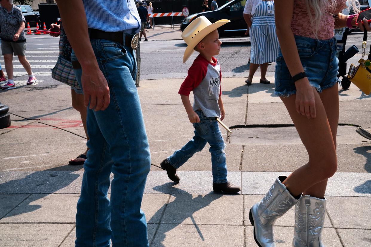 Gabriel Lawson, 5, of South Bend, Ind., and his parents meander down Fourth Avenue on the first day of CMA Fest in Nashville, Tenn., Thursday afternoon, June 8, 2023. Gabriel had a drumstick a drummer had given him when they visited Kid Rock's Big Honky Tonk Rock N' Roll Steakhouse.
