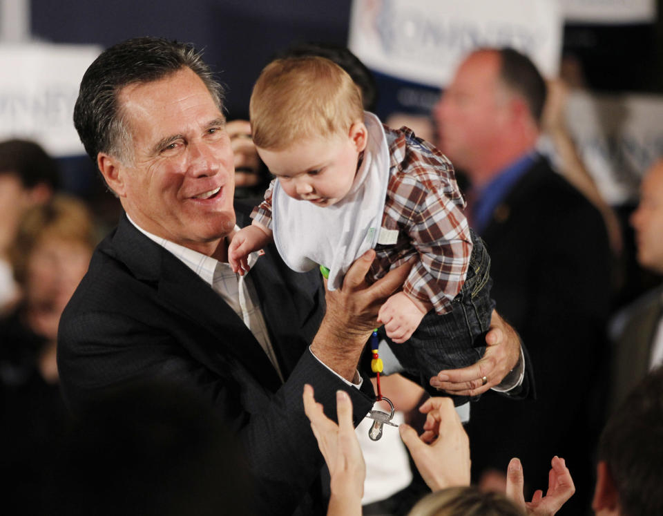 Republican presidential candidate and former Massachusetts Governor Mitt Romney hands a baby back to his parents after posing for a picture as he meets with supporters at the Hall at Senate's End in Columbia, South Carolina, January 11, 2012. REUTERS/Jason Reed