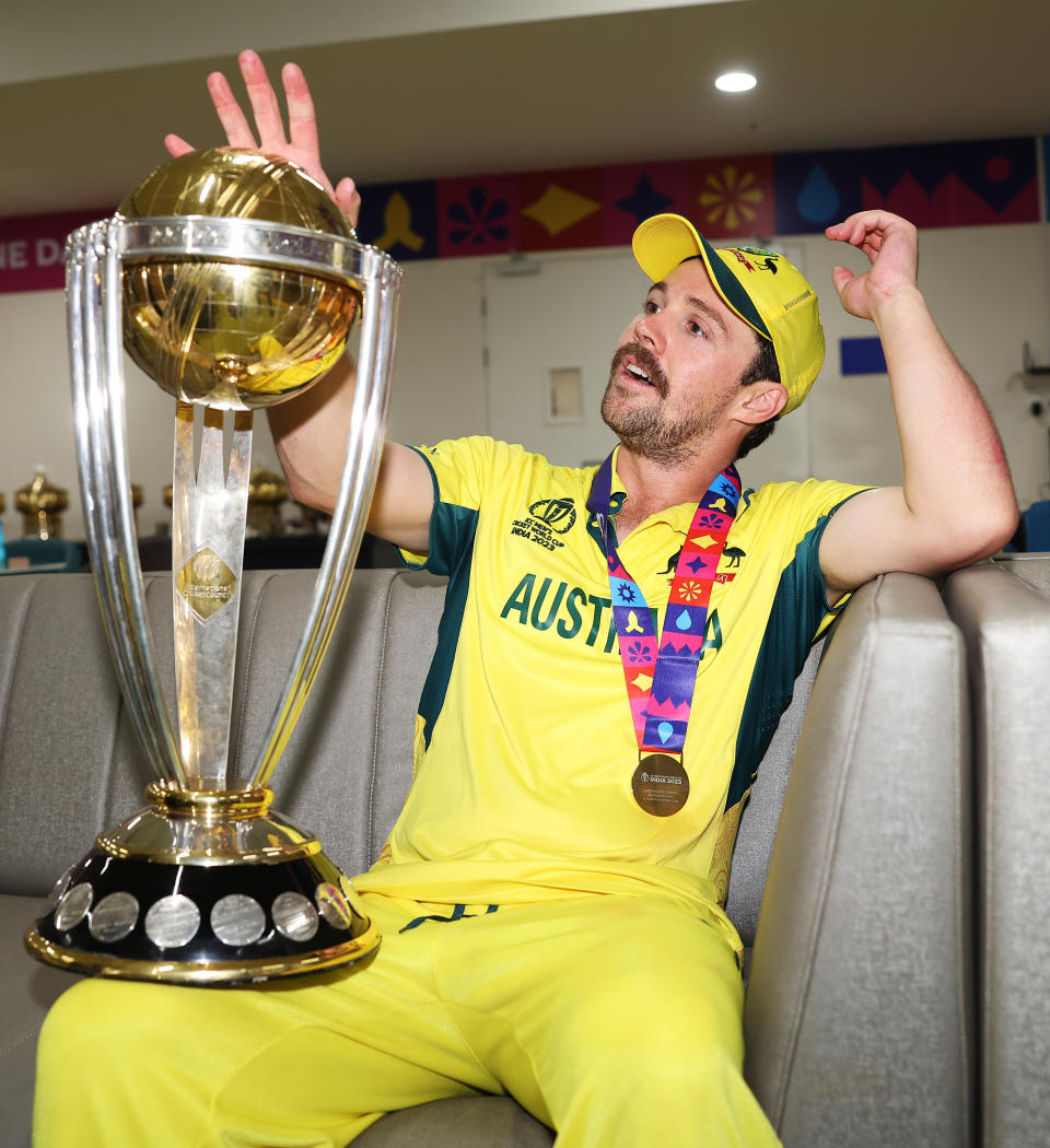 Travis Head holding the World Cup trophy.