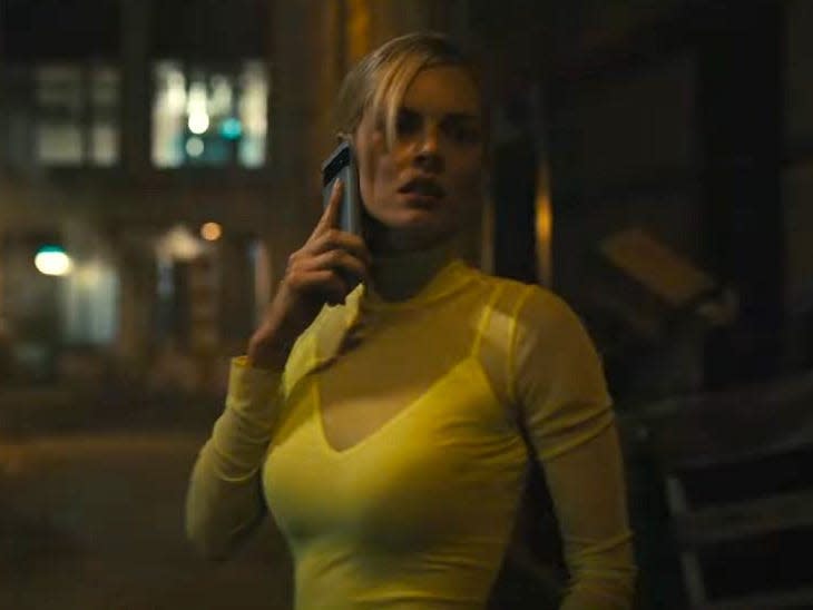 Samara Weaving as Sasha holding a phone.