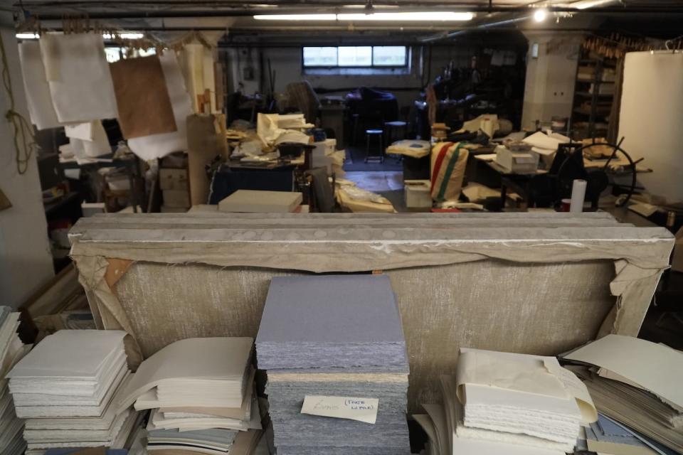 Piles of paper, machinery and all kinds of curio are scattered throughout the basement mill. 