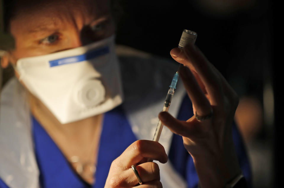 Doctor Claire Chatt prepares the Pfizer-BioNTech vaccine inside Salisbury Cathedral in Salisbury, England, Wednesday, Jan. 20, 2021. Salisbury Cathedral opened its doors for the second time as a venue for the Sarum South Primary Care Network COVID-19 Local Vaccination Service. (AP Photo/Frank Augstein)