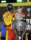 Joey Logano holds his son Hudson in the trophy after winning the NASCAR Cup Series championship auto race at Homestead-Miami Speedway, Sunday, Nov. 18, 2018, in Homestead, Fla. (AP Photo/Terry Renna)