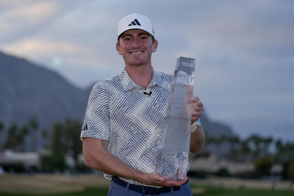 Nick Dunlap holds the trophy after winning the American Express golf tournament, Sunday, Jan. 21, 2024, in La Quinta, Calif. (AP Photo/Ryan Sun)