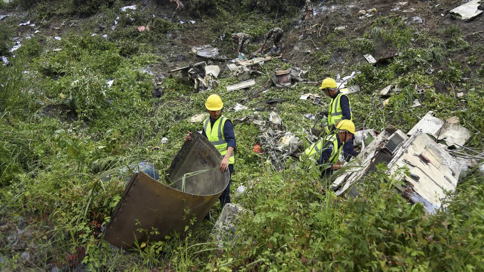 Rescue workers search the plane crash site at Tribhuvan International Airport. - Sujan Gurung/AP