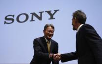 Sony Corp President and Chief Executive Officer Kazuo Hirai (L) shakes hands with Michael Lynton, CEO Sony Entertainment and CEO and chairman Sony Pictures Entertainment, during an investors' conference at the company's headquarters in Tokyo November 18, 2014. REUTERS/Toru Hanai