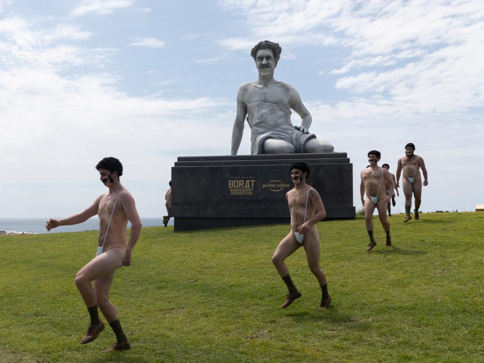 Not so very nice: The dubious Borat statue surrounded by performers in Bondi, SydneyGetty Images