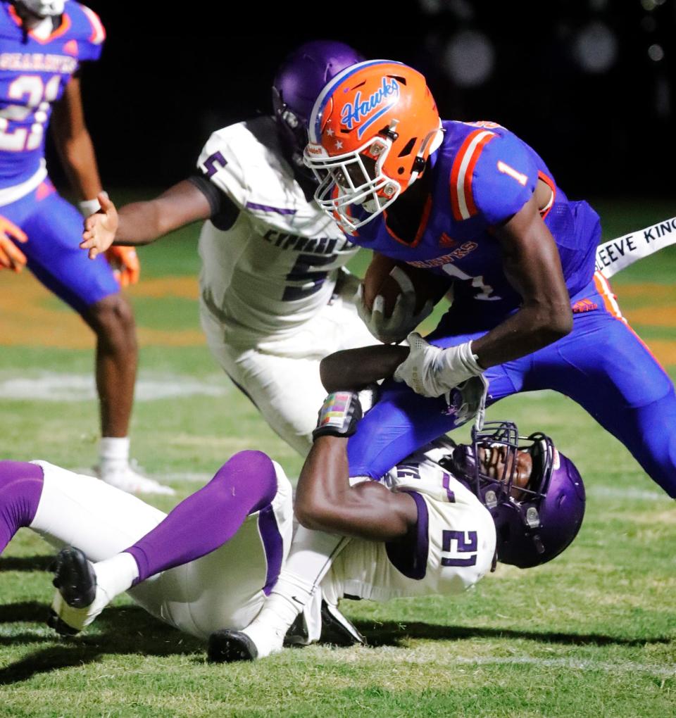 Cypress Lake defender Almirian Thomas holds on to Cape Coral running back Jermaine Skinner. Cape Coral High School hosted Cypress Lake for a Friday night football showdown September 15, 2023. Ricardo Rolon/USA TODAY NETWORK-FLORIDA
