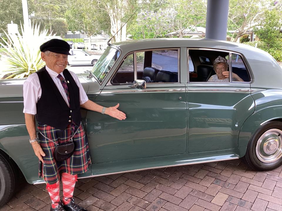 Katie MacRae in an old car with a chauffeur on her 106th birthday.