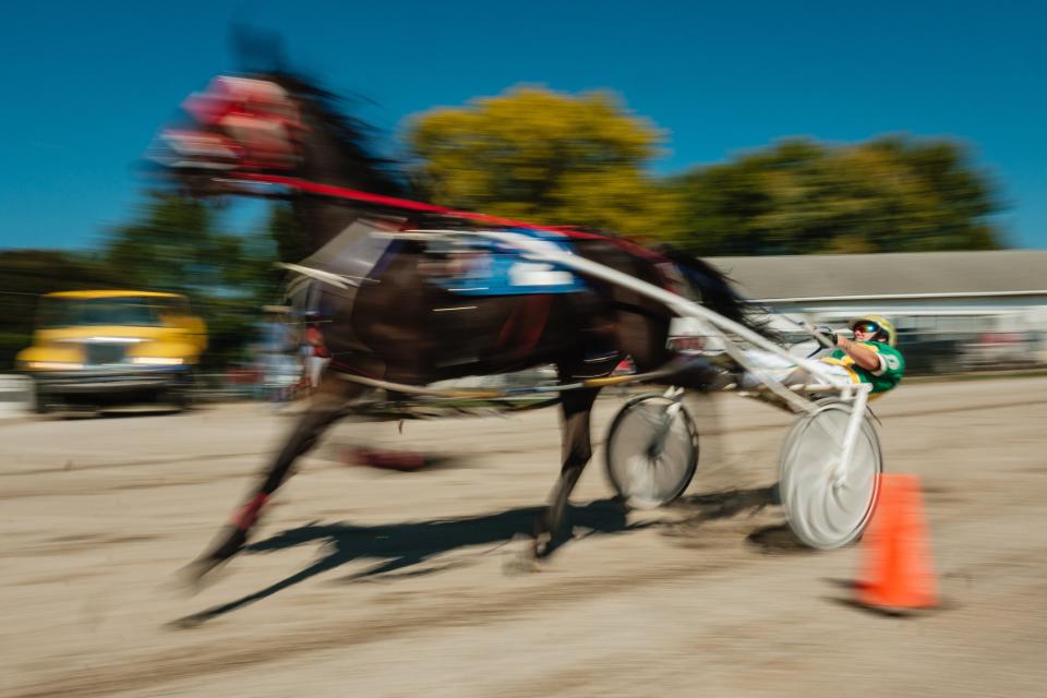 A harness racer flies around the track midday during the Tuscarawas County Fair, Friday, Sept. 22 in Dover.