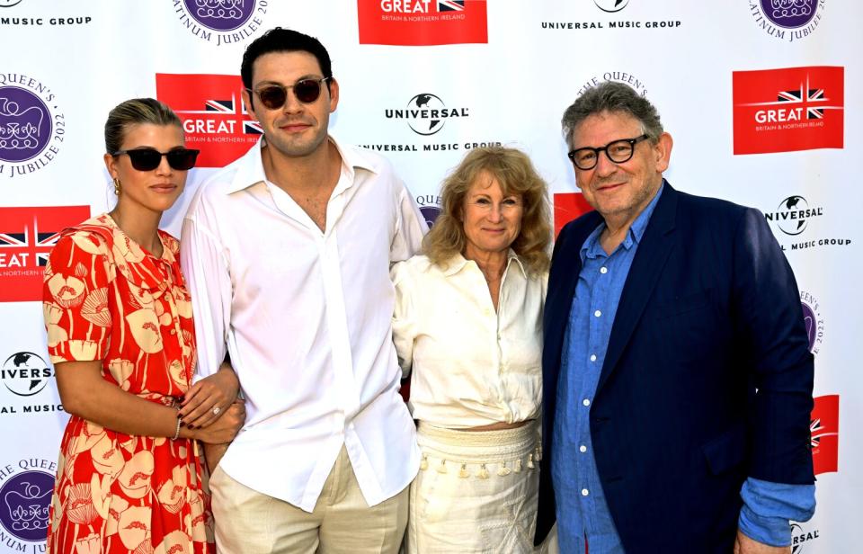 Four people pose for a photo on a red carpet