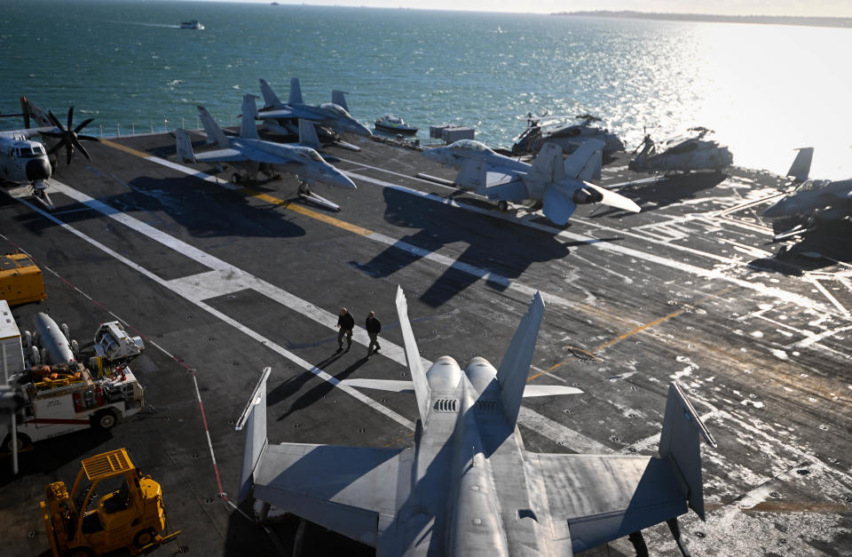 GOSPORT, ENGLAND - NOVEMBER 17: Navy personnel walk past an F-18 jet fighters on the flight deck of USS Gerald R. Ford, on November 17, 2022 in Gosport, England. The USS Gerald R. Ford (CVN-78) is the lead ship of her class of United States Navy aircraft carriers. Commissioned in 2017, the carrier is powered by two nuclear reactors with a length of 1,092 feet and displacement of 100,000 long tons full load. With a crew of approximately 4,550, 75+ aircraft and state of the art weaponry, the first-in-class is the US Navy's most advanced aircraft carrier. USS Gerald Ford has been carrying out NATO exercises in the North Atlantic with French and Spanish ships. (Photo by Finnbarr Webster/Getty Images)