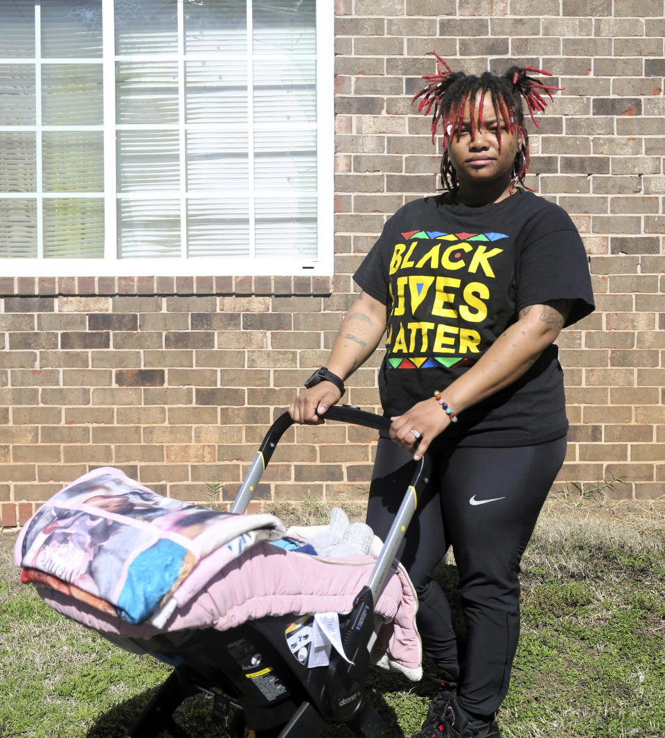 Nia Thomas stands in front of her Atlanta home on Feb. 14, 2024, with her 4-month-old daughter, Nilah, inside the stroller. Thomas was bailed out of jail by the nonprofit Barred Business in 2022 through the “Mama’s Day Bail Out,” initiative, a practice that could be significantly restricted, if not criminalized, under a recently passed Georgia bill. (AP Photo/R.J. Rico)