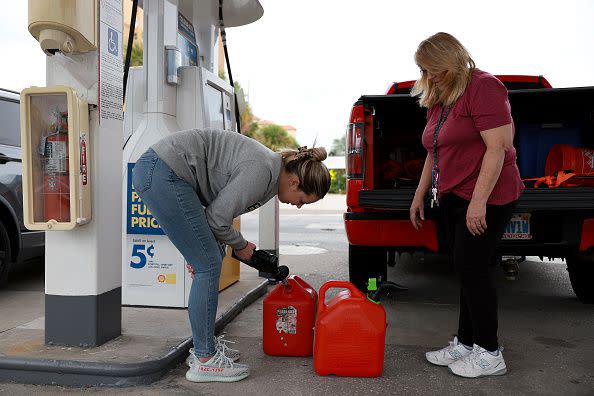 ST. PETERSBURG BEACH, FLORIDA - SEPTEMBER 27:  Brittany Andrias (L) and Cathy Dalrymple fill gas containers at a station before the possible arrival of Hurricane Ian on September 27, 2022 in St Petersburg Beach, Florida. Hurricane Ian is expected to make landfall in the Tampa Bay area Wednesday night into early Thursday morning. (Photo by Joe Raedle/Getty Images)