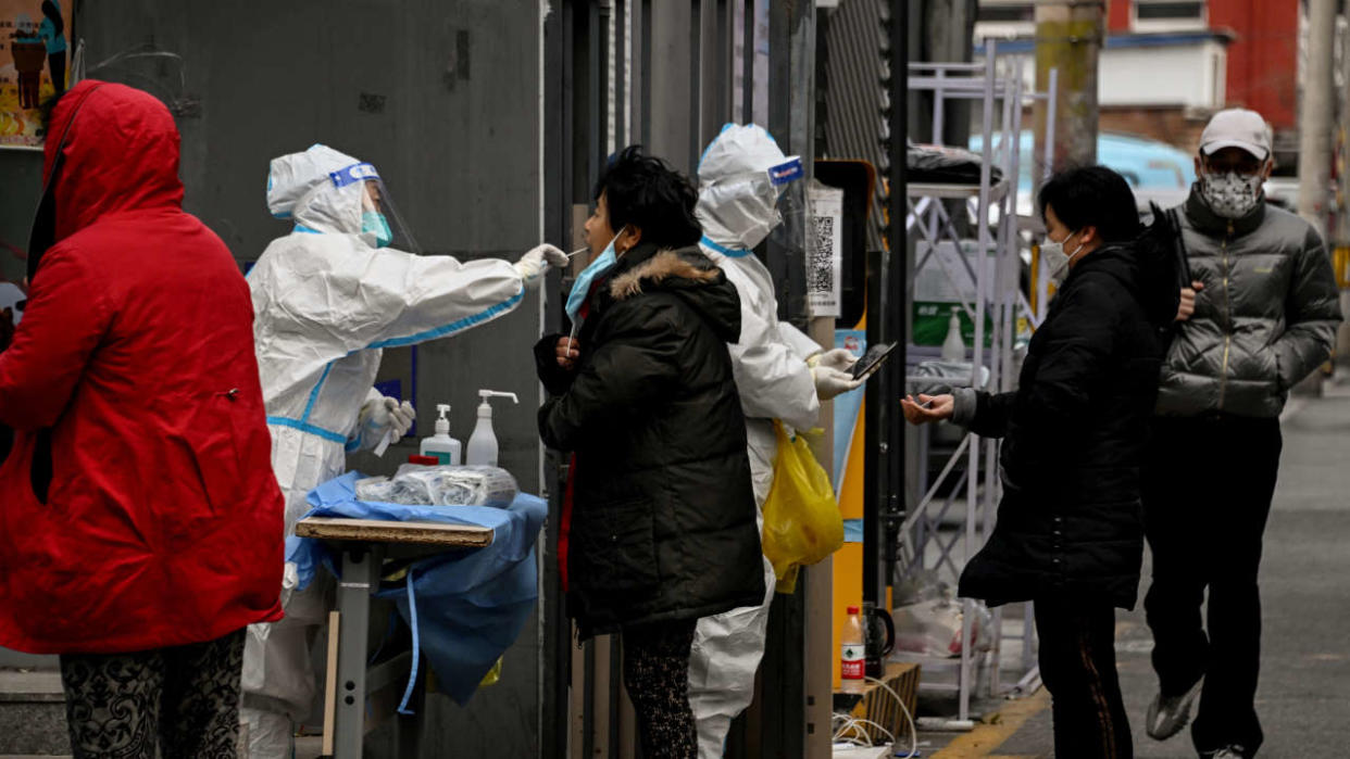 Des résidents subissent des tests par écouvillonnage dans une zone résidentielle sous confinement en raison des restrictions liées au coronavirus Covid-19, à Pékin, le 29 novembre 2022. (Photo par Noel CELIS / AFP)