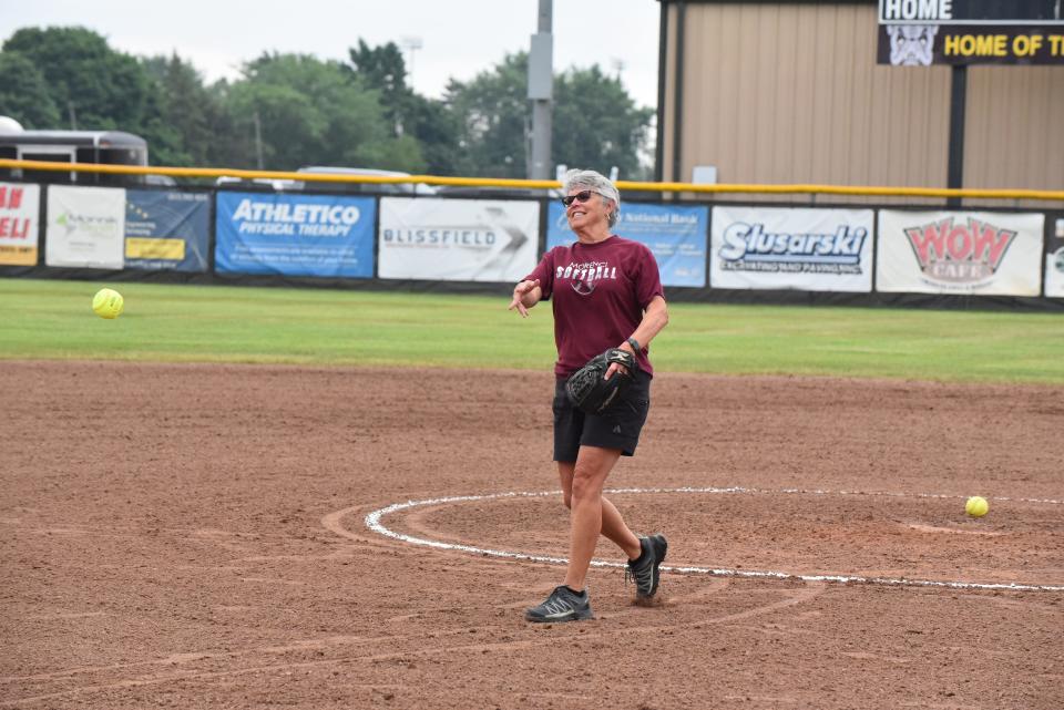 Morenci head softball coach Kay Johnson delivers the ceremonial first pitch for the 2022 Lenawee County Senior All-Star Softball Game.