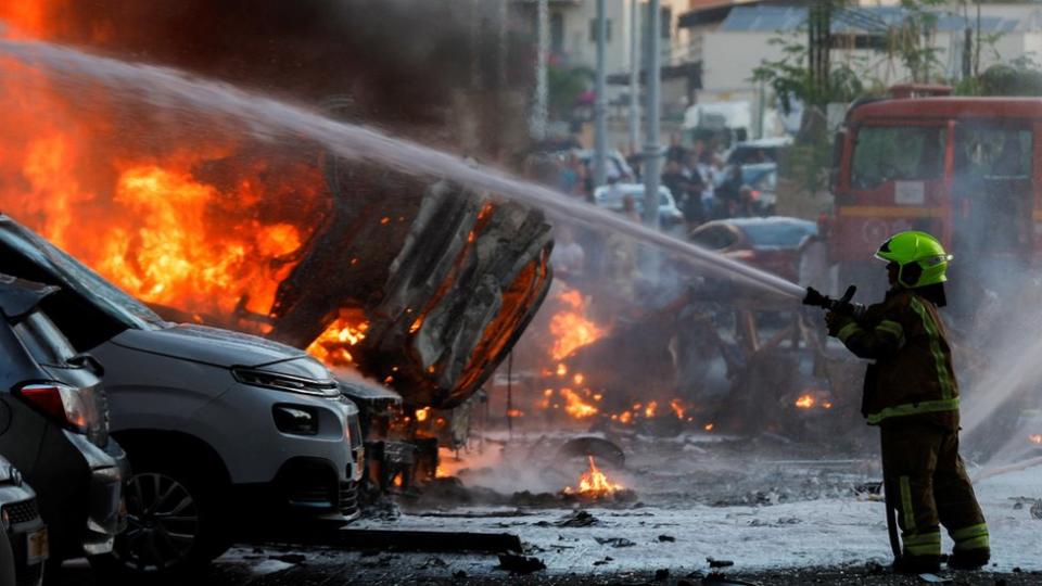 An emergency personnel works to extinguish fire after rockets were launched from the Gaza Strip, in Ashkelon, Israel October 7, 2023.