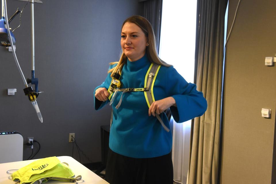 Kristen Coleman, PhD, study investigator at University of Maryland School of Public Health tries on personal virus sampler device that captures and analyzes air exhalation