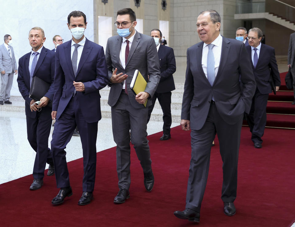 In this photo released by Russian Foreign Ministry Press Service, Russian Foreign Minister Sergey Lavrov, right, and Syrian President Bashar al-Assad, second left, walk after their talks in Damascus, Syria, Monday, Sept. 7, 2020. Russia's foreign minister has met with Syrian President Bashar Assad shortly after landing in the Syrian capital on his first visit since 2012. Russia has been a close ally of Assad in Syria's long and bloody nine-year-long civil war, lending his government in Damascus vital military, economic and political support. (Russian Foreign Ministry Press Service via AP)