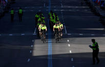 Boston Police officers on bicycles ride down the finish line. REUTERS/Gretchen Ertl