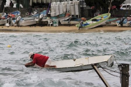 A fisherman checks his boat in Acapulco, Mexico October 22, 2015. REUTERS/Claudio Vargas