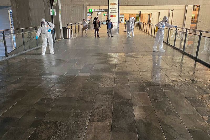 Members of the Military Emergency Unit (UME) wearing protective suits disinfect corridors and hand rails at Santa Justa train station, in Seville