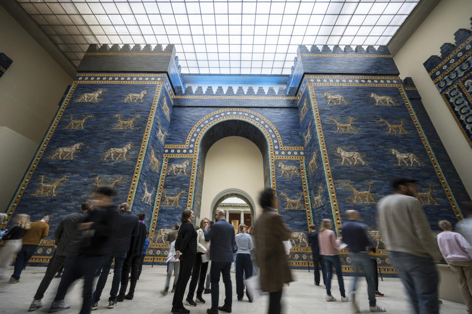 Visitors in front of Ishtar Gate of Babylon at Pergamon Museum in Berlin, Tuesday, April 4, 2023. A new light and sound installation by British contemporary artist Liam Gillick, part of the show Filtered Time, opened Tuesday at one of the German capital's most popular museums. (AP Photo/Stefanie Loos)