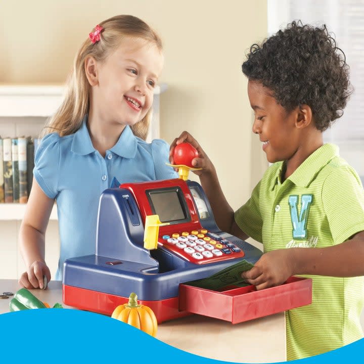 Two kid splaying with cash register