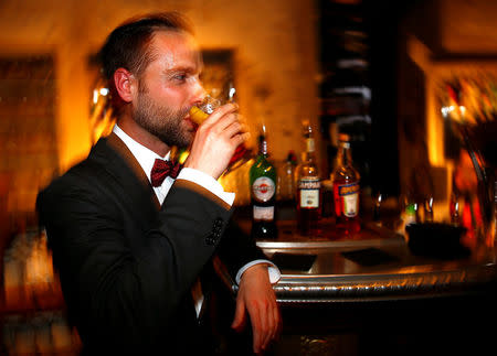 A man drinks a cocktail made with Martini at the "Spirit de Milan" in Milan, Italy, May 19, 2018. REUTERS/Stefano Rellandini