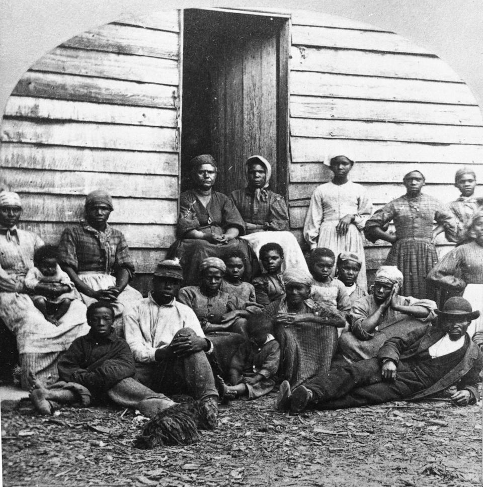 PHOTO: A group of fugitive slaves who were emancipated upon reaching the North, sitting outside a house, possibly in Freedman's Village in Arlington, Va., in the mid 1860s. (Hulton Archive/Getty Images)