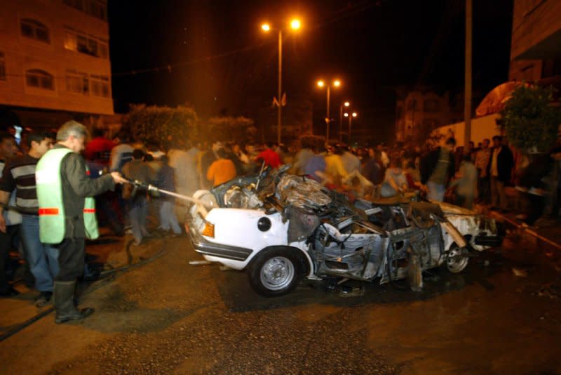 Palestinians search in the car of Hamas leader in Gaza Abdel Aziz Rantisi following an Israeli missile strike in Gaza City on April 17, 2004. Rantisi died later of his wounds, according to hospital officials. File Photo by Ismael Mohamad/UPI