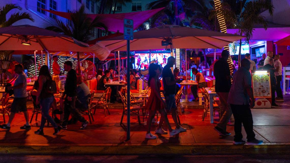 People walk along Ocean Drive in Miami Beach on Friday, March 3, 2023.