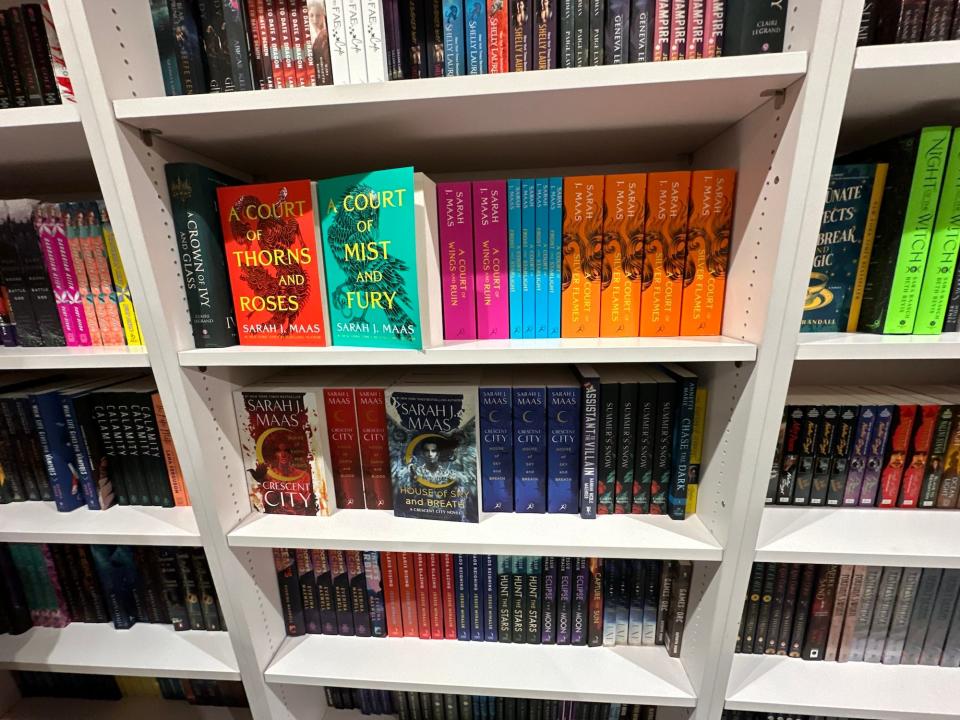 A bookshelf with Sarah J. Maas books on it.