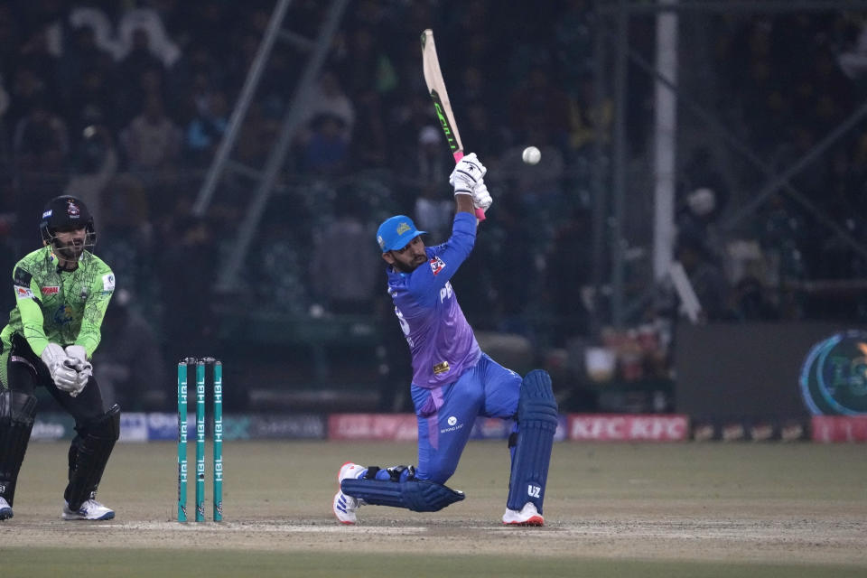 Multan Sultans' Usman Khan, center, plays a shot during the Pakistan Super League T20 cricket match between Multan Sultan and Lahore Qalandars, in Lahore, Pakistan, Tuesday, Feb. 27, 2024. (AP Photo/K.M. Chaudary)