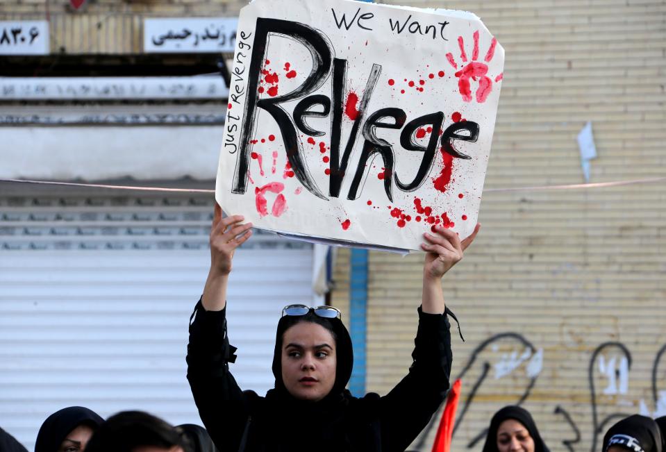 An Iranian mourner holds a placard during the final stage of funeral processions for slain top general Qasem Soleimani, in his hometown Kerman on January 7, 2020. - Soleimani was killed outside Baghdad airport on January 3 in a drone strike ordered by US President Donald Trump, ratcheting up tensions with arch-enemy Iran which has vowed "severe revenge". The assassination of the 62-year-old heightened international concern about a new war in the volatile, oil-rich Middle East and rattled financial markets. (Photo by ATTA KENARE / AFP) (Photo by ATTA KENARE/AFP via Getty Images)