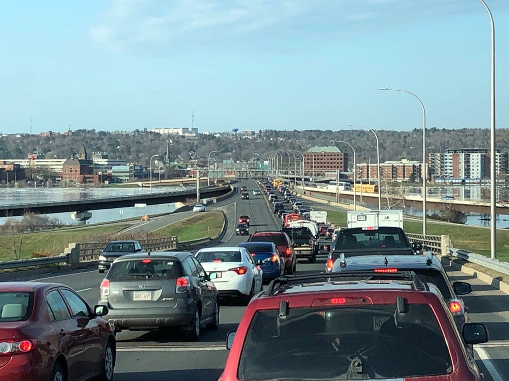 Traffic on Fredericton's Westmorland Street Bridge. The federal government estimates that the average New Brunswick car travels 14.3 kilometres on a litre of fuel. In calculating exaggerated carbon tax costs for its official web page, the New Brunswick government used the gas guzzling figure of 11.4 kilometres per litre instead. (Gary Moore/CBC News - image credit)