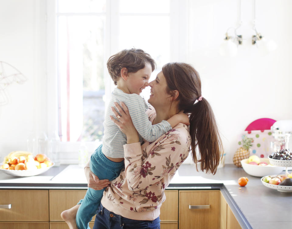 A mother holding her son as they both smile