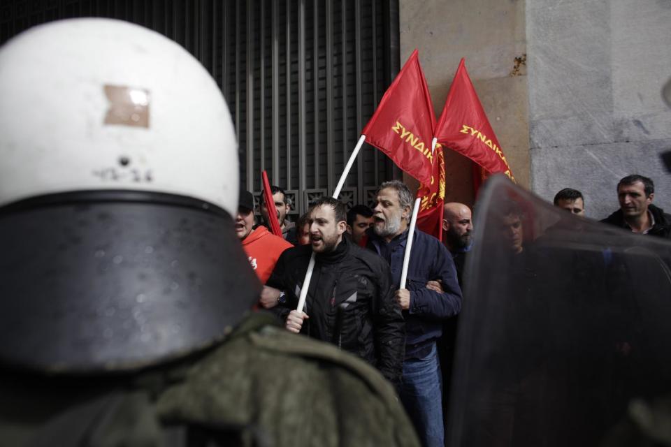 Protesters affiliated to the Communist Party shout slogans as riot policemen block them during a demonstration against austerity measures in Athens, on Thursday March 6, 2014. Riot police have used tear gas and pepper spray during scuffles with union members protesting austerity measures, during a ban on demonstrations in parts of central Athens due to a visit by German President Joachim Gauck. Scuffles broke out when a group of several dozen demonstrators attempted to break through a police cordon on a major avenue in an effort to march to the Finance Ministry. (AP Photo/Kostas Tsironis)