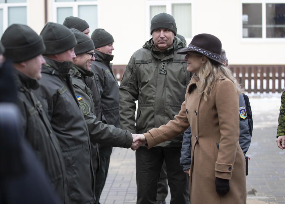 In this photo provided by Ukrainian National Guard Press Office Canada's Minister of Foreign Affairs Melanie Joly, right, greets Ukrainian soldiers during her visit to the National Guard base close to Kyiv, Ukraine, Tuesday, Jan. 18, 2022. (Ukrainian National Guard Press Office via AP)