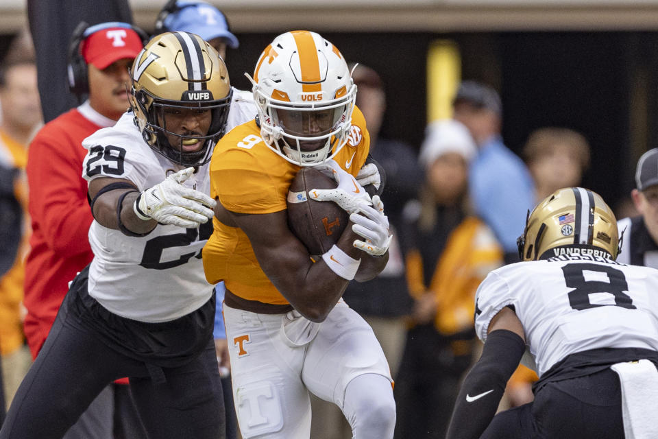 Tennessee wide receiver Ramel Keyton (9) runs for yardage as he's hit by Vanderbilt defensive back Miles Capers (29) during the first half of an NCAA college football game Saturday, Nov. 25, 2023, in Knoxville, Tenn. (AP Photo/Wade Payne)