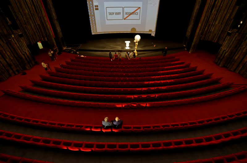 Staff members prepare a broadcast of an opening ceremony inside an empty cinema in Karlovy Vary