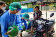 Volunteers help a coronavirus disease (COVID-19) patient with extra oxygen in the town of Kale, Sagaing Region, Myanmar
