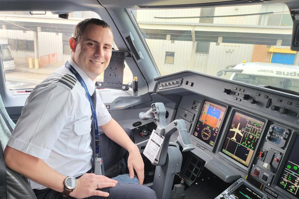 Travis Houser, recent graduate of Middle Tennessee State University's Aeronautical Science master's program, sits in the cockpit at Charlotte Douglas International Airport in Charlotte, N.C., on Dec. 24, 2021, after completing his probationary training period as a first officer for Republic Airlines.