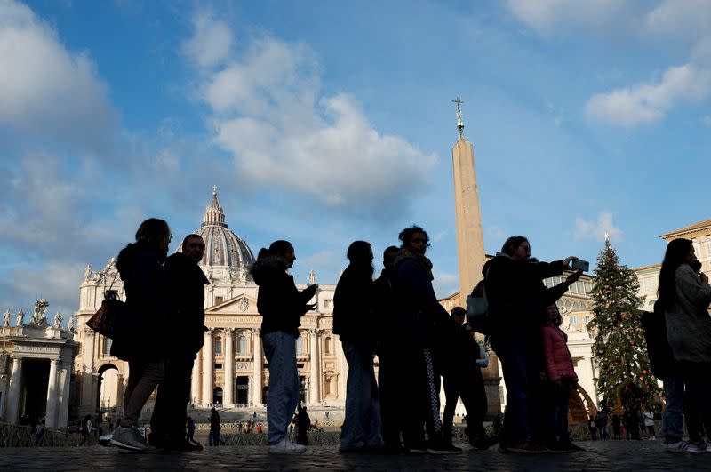 FILE PHOTO: People gather following the announcement of the worsening of former Pope Benedict's health, at the Vatican