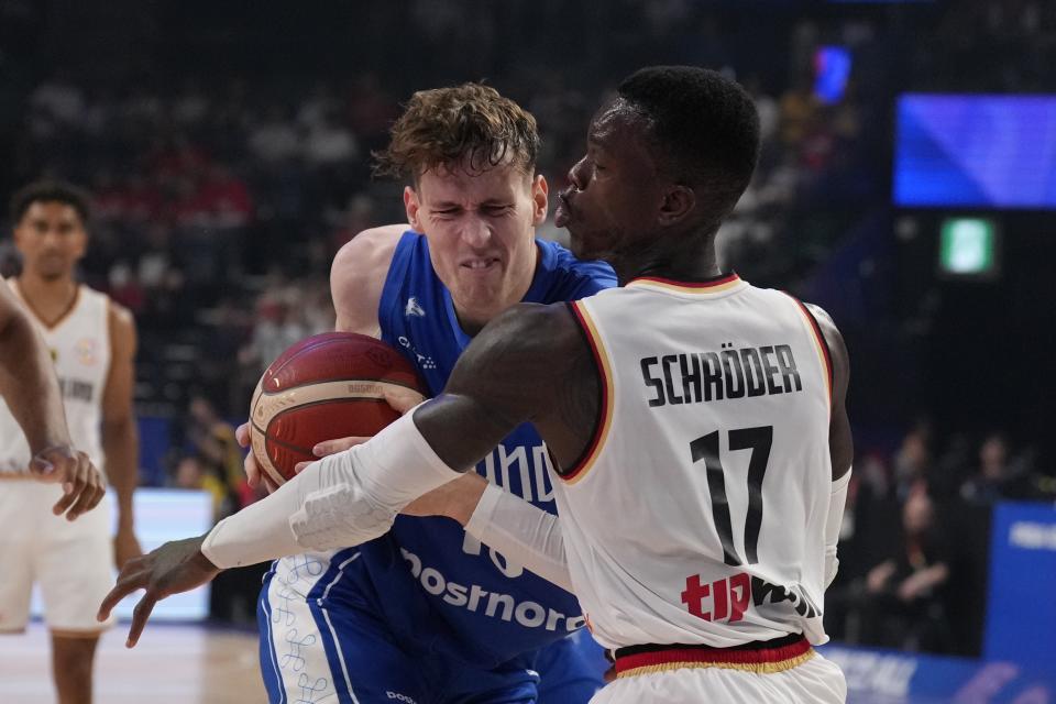 Finland forward Mikael Jantunen (18) drives against Germany guard Dennis Schroder (17) in the first half of their Basketball World Cup group E match in Okinawa, southern Japan, Tuesday, Aug. 29, 2023. (AP Photo/Hiro Komae)