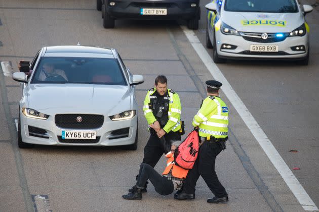 <strong>Surrey Police officers haul an Insulate Britain climate activist from the carriageway of the M25.</strong> (Photo: Mark Kerrison via Getty Images)
