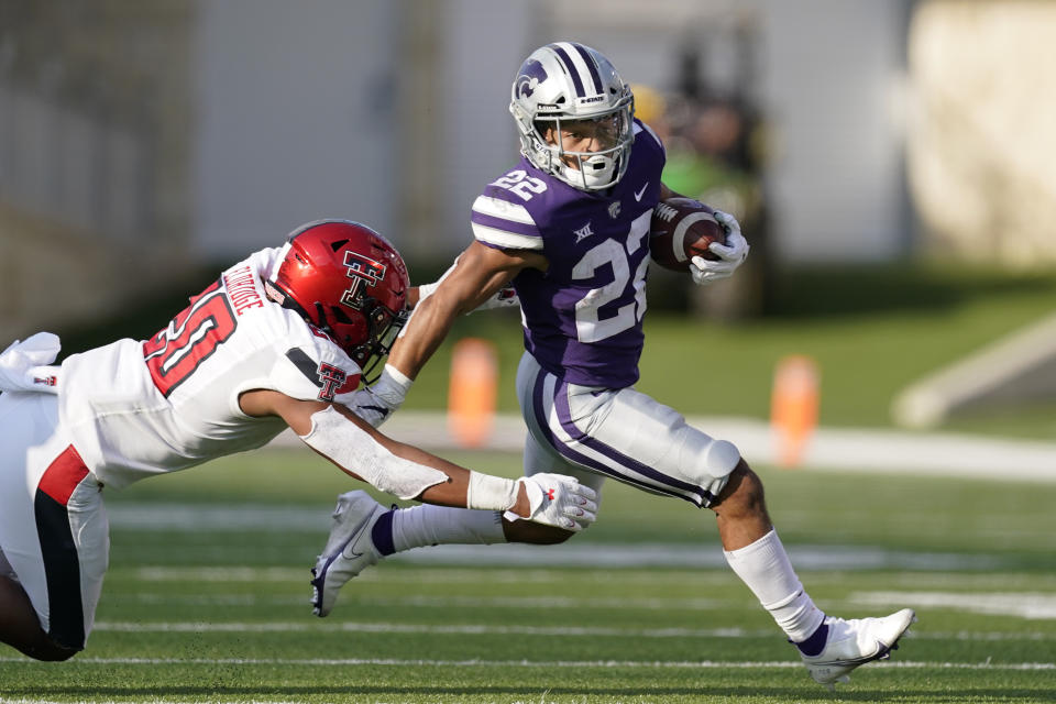 Kansas State running back Deuce Vaughn (22) gets past Texas Tech linebacker Kosi Eldridge (20) as he runs for a first down during the second half of an NCAA college football game Saturday, Oct. 3, 2020, in Manhattan, Kan. (AP Photo/Charlie Riedel)